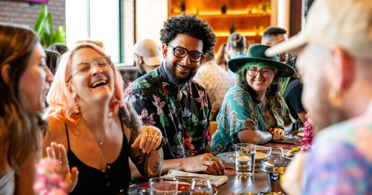 Bartenders gathered at communal table during Camp Runamok industry event, sharing camaraderie and laughter