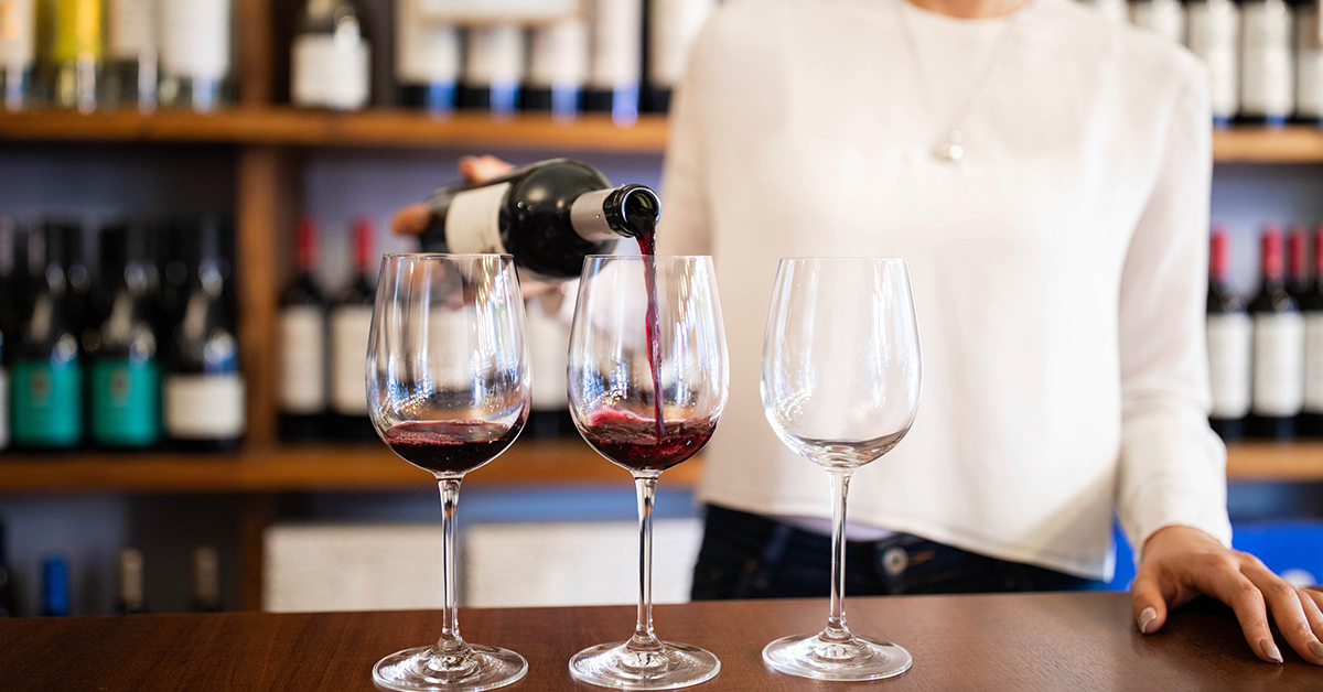 Young alcohol server demonstrating responsible service practices at wine bar counter