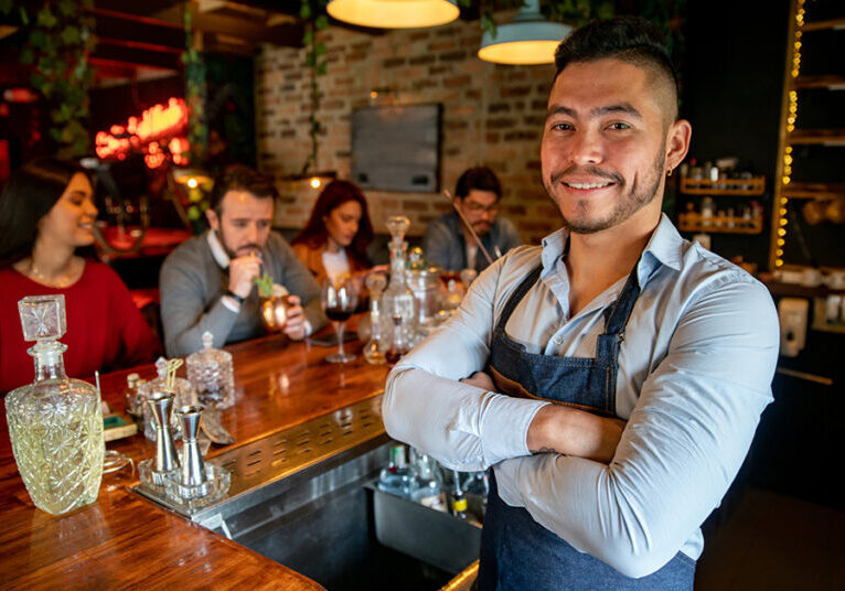 Bartender standing confidently behind bar after renewing MAST permit