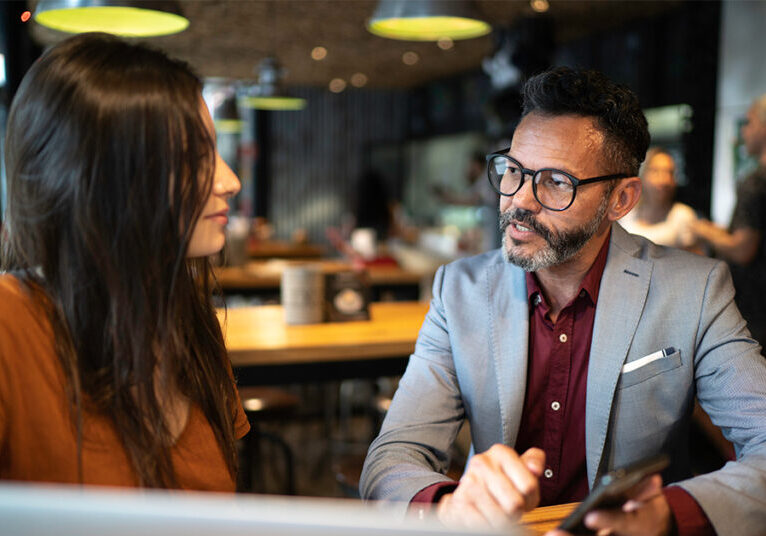 Restaurant workers collaborating and reviewing resources at café table