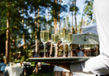 Waiter serving champagne at outdoor wedding event with professional alcohol service