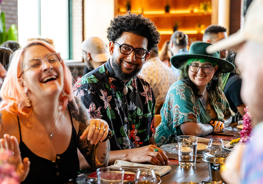 Bartenders gathered at communal table during Camp Runamok industry event, sharing camaraderie and laughter